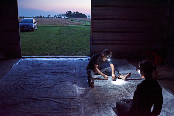 Car, field, and two artists with head lamps